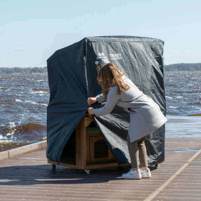 deVries - Schutzhülle Premium, atmungsaktive Schutzhülle für Strandkorb wird auf einem Steg geschlossen.