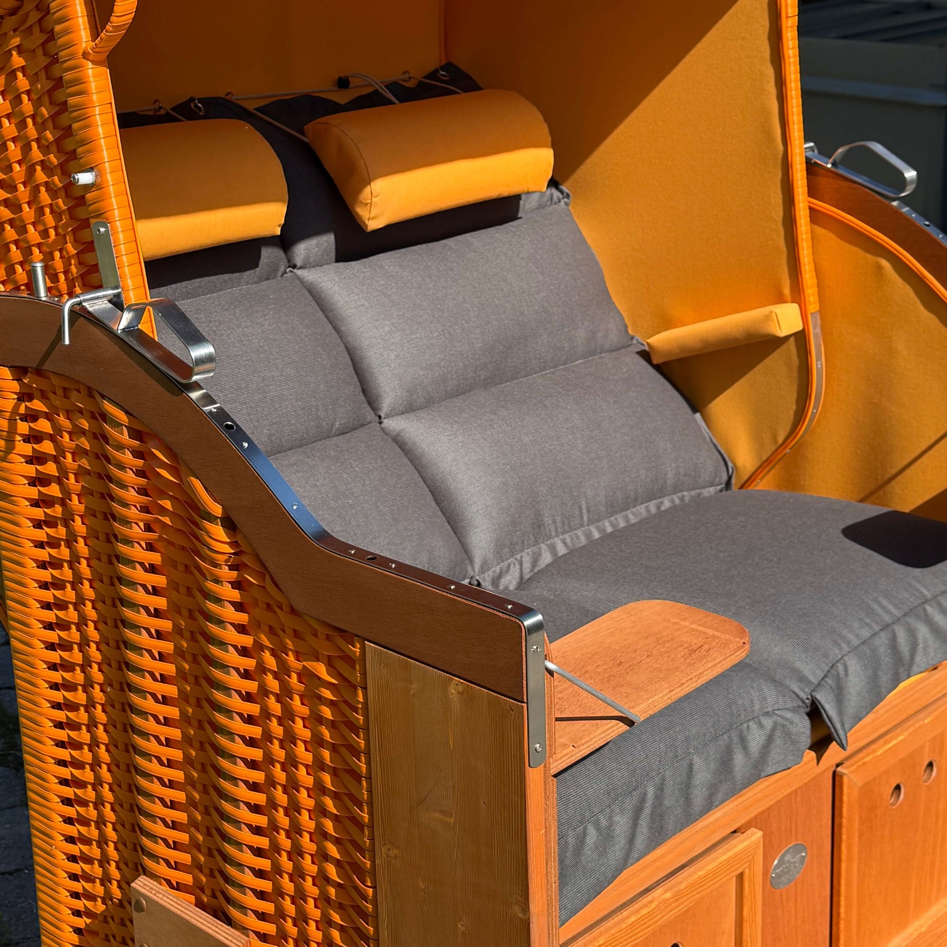 Strandkorb Sonnenpartner Modell Classic PE orange mit gemütlicher Polsterung und Holzdetails im eleganten Design.
