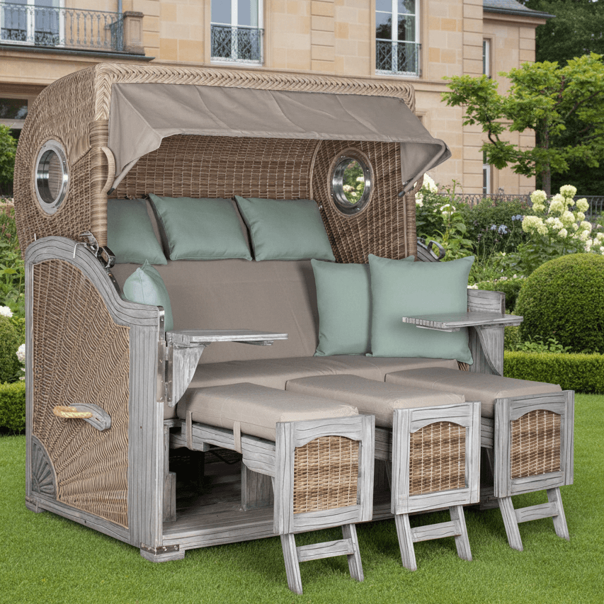 Strandkorb deVries PURE Seemöwe Vintage PE white kubu Dessin 483 XXL auf Gartenrasen vor Villa mit Bullaugen und Fußstützen