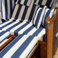 Strandkorb mit blau-weißen gestreiften Polstern und Kopfkissen für entspannende Sommermomente.