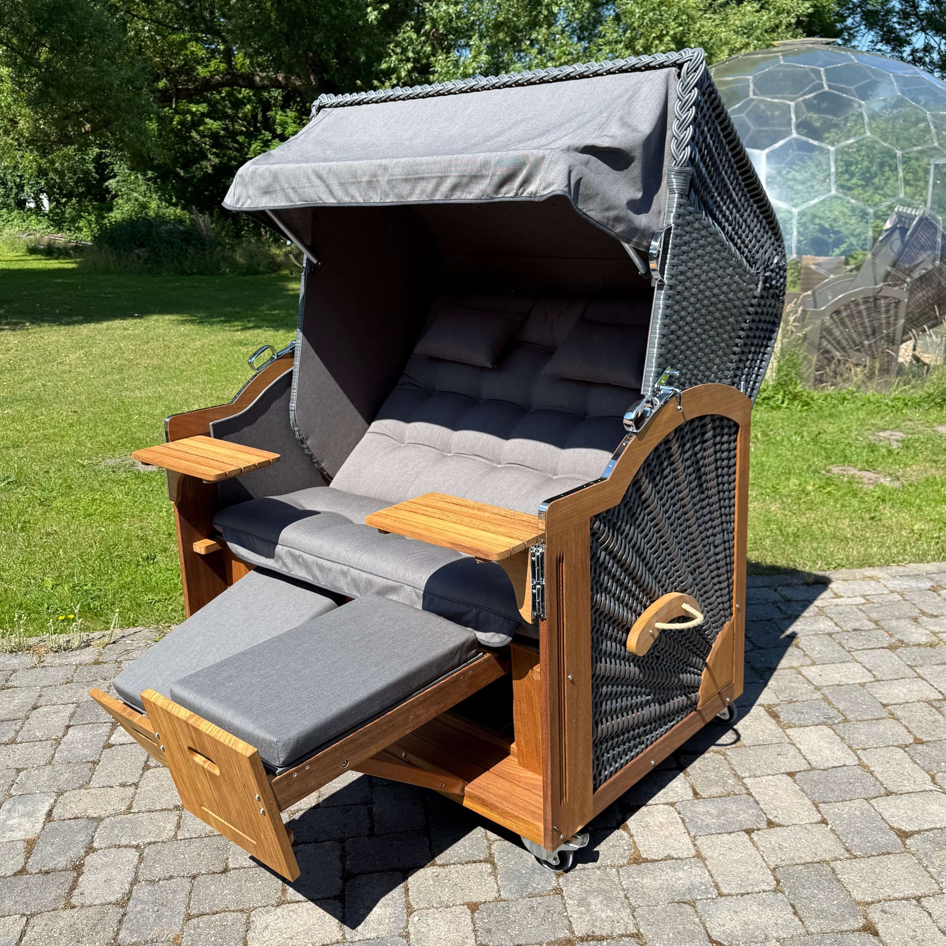 Strandkorb Prieß Modell Meister aus Iroko Holz mit dunkelgrauem PE Geflecht und anthrazitgrauem Stoff, ideal für den Garten.