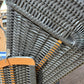 Strandkorb aus anthrazit PVC-Geflecht mit Holzdetails, ideal für das entspannte Sitzen im Freien.