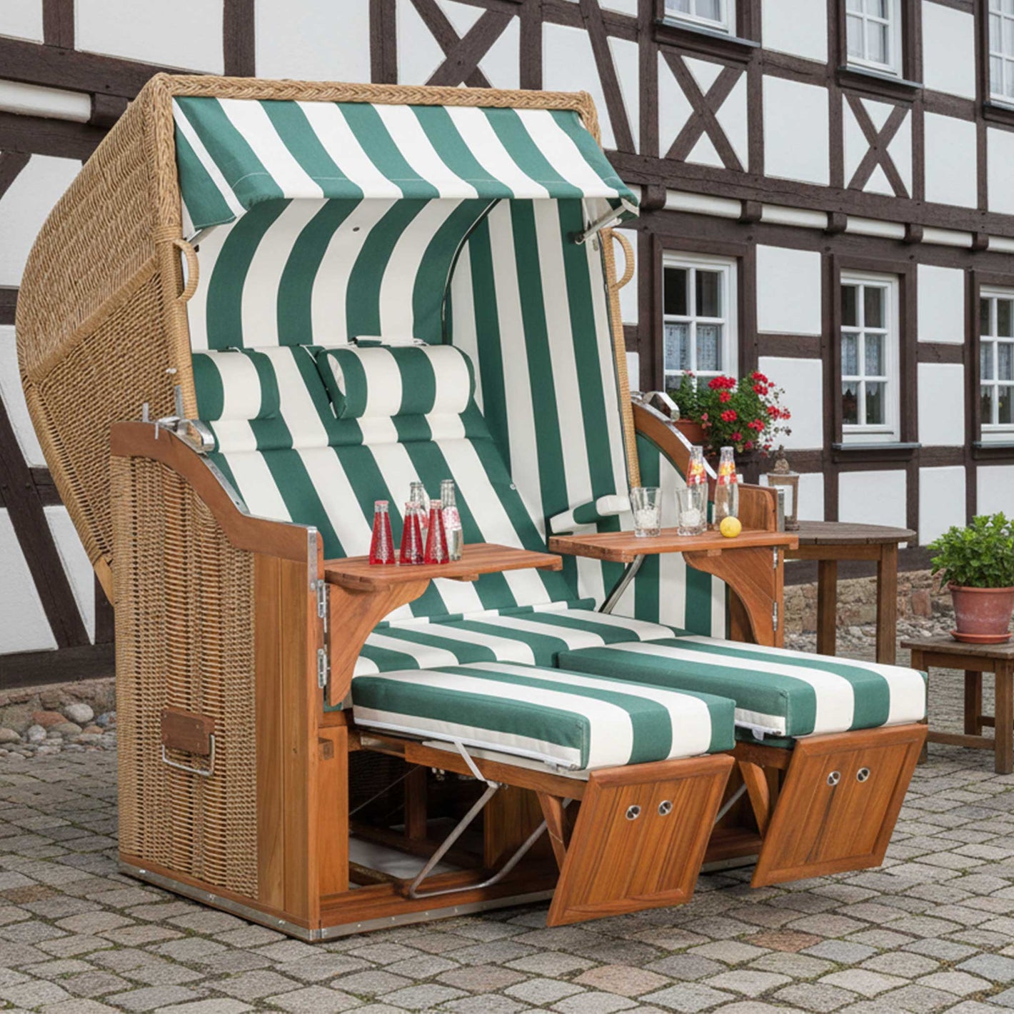 Strandkorb 2-Sitzer Classic Teak in grün-weiss gestreift mit komfortablen Polstern im Garten.