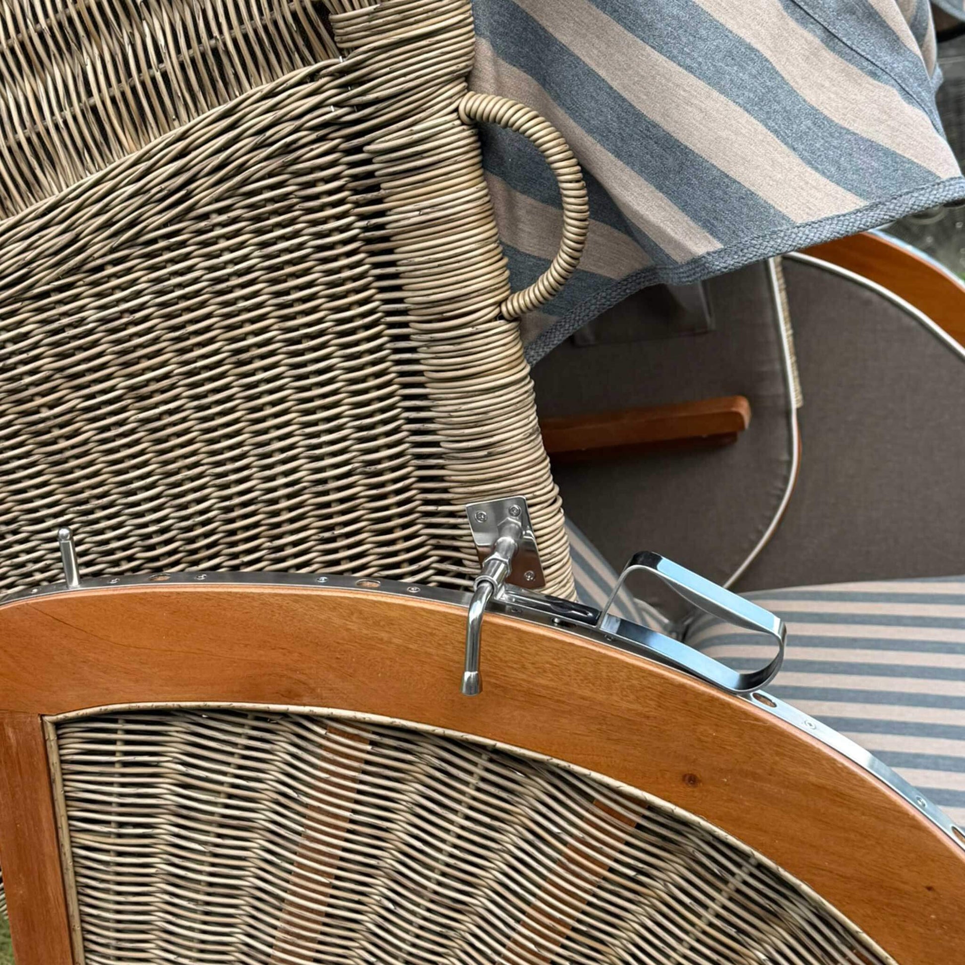 Detailansicht des Strandkorb Keitum Mahagoni 130 cm mit Rattangeflecht und blauen Streifen.