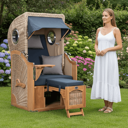Strandkorb Mr. Deko Düne Bullaugen Teak PE-shell 1-Sitzer blau auf Gartenrasen mit Frau in weißem Sommerkleid daneben