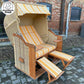Strandkorb Sonnenpartner Modell Classic PE Rundgeflecht mit gelb gestreifter Polsterung und Holzdetails.