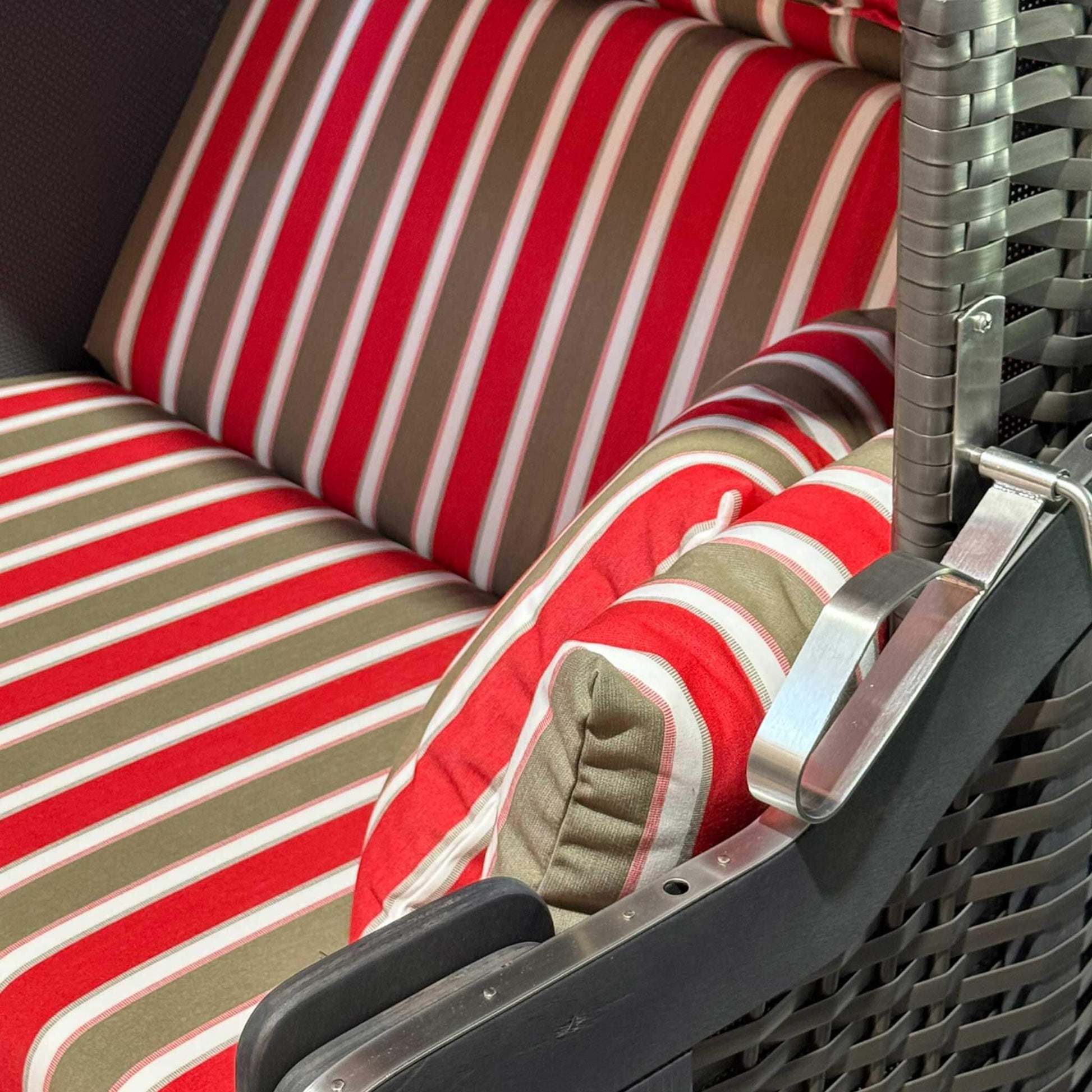 Strandkorb Kiel 255 Plus mit gestreiften Kissen in Rot und Beige, ideal für den Außenbereich.