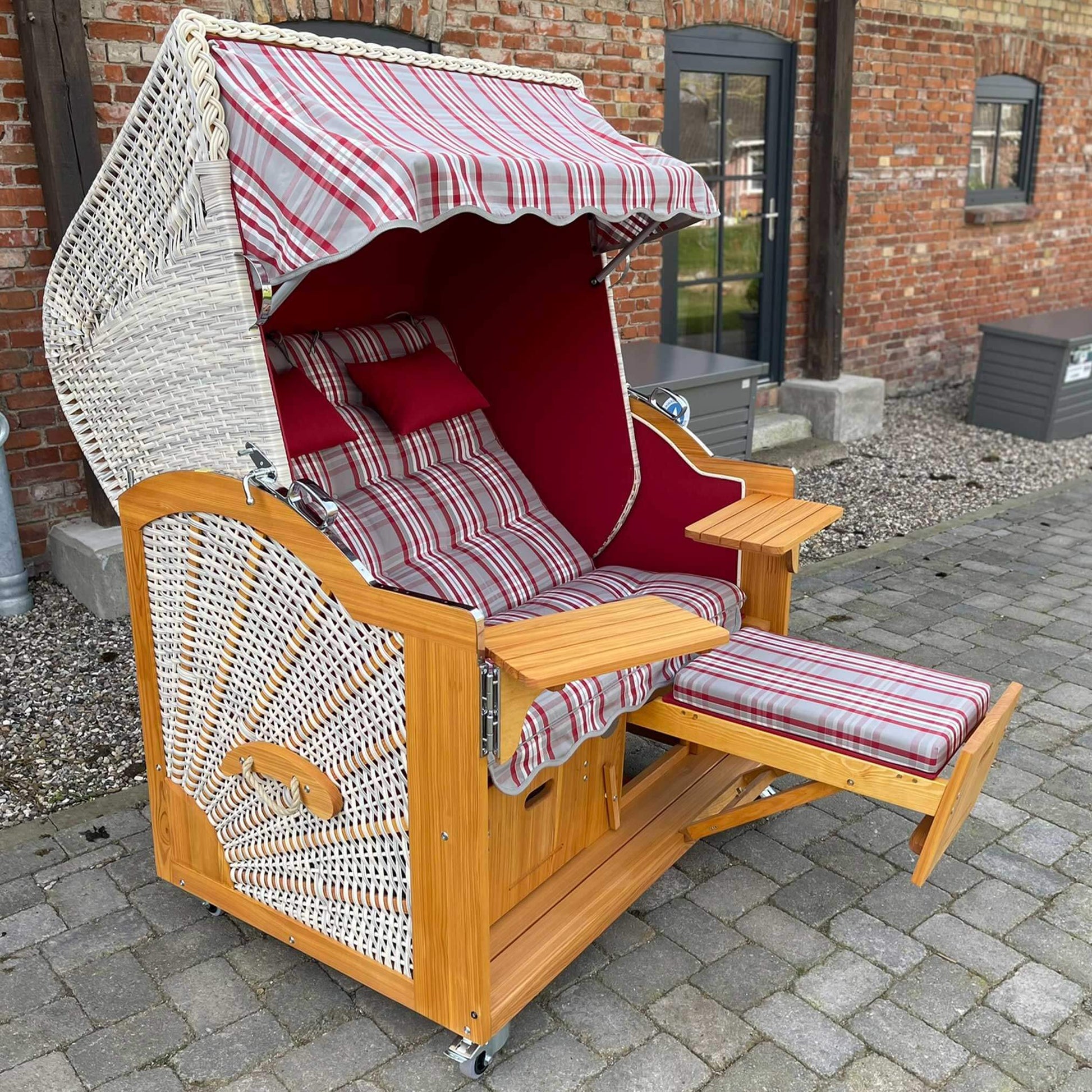 Strandkorb Prieß rot, Modell Meister aus Lärche Holz mit taupe PE Geflecht und rot-taupe Dessin, ideal zum Entspannen.