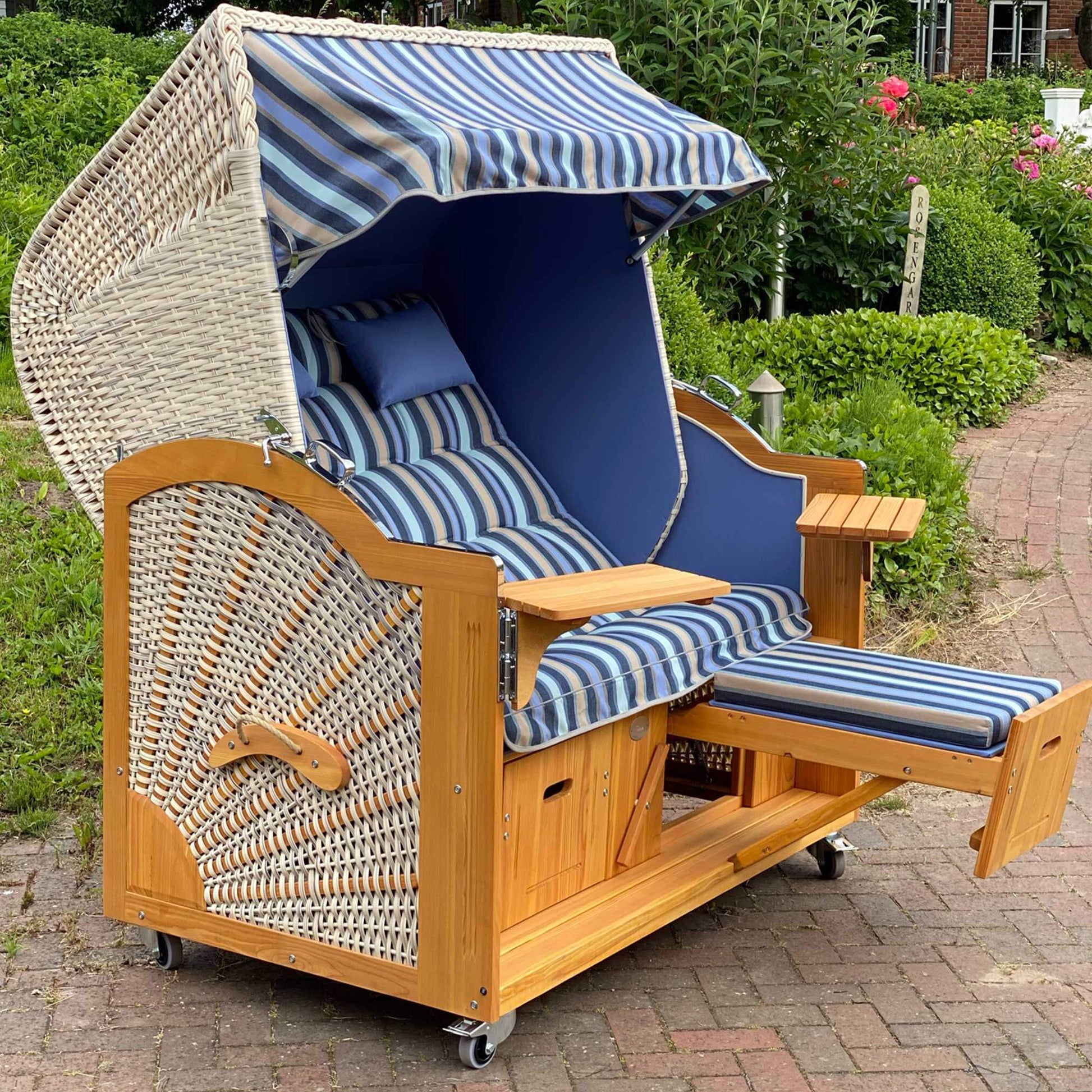 Strandkorb Prieß Modell Meister aus Lärche mit PE Geflecht naturoptik und blau-weiß gestreiftem Stoffdessin im Garten