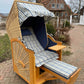 Strandkorb Prieß, Modell Meister, aus Lärche Holz mit PE Geflecht, blau-weißem Stoffdessin, gemütlicher Sitzplatz im Freien.