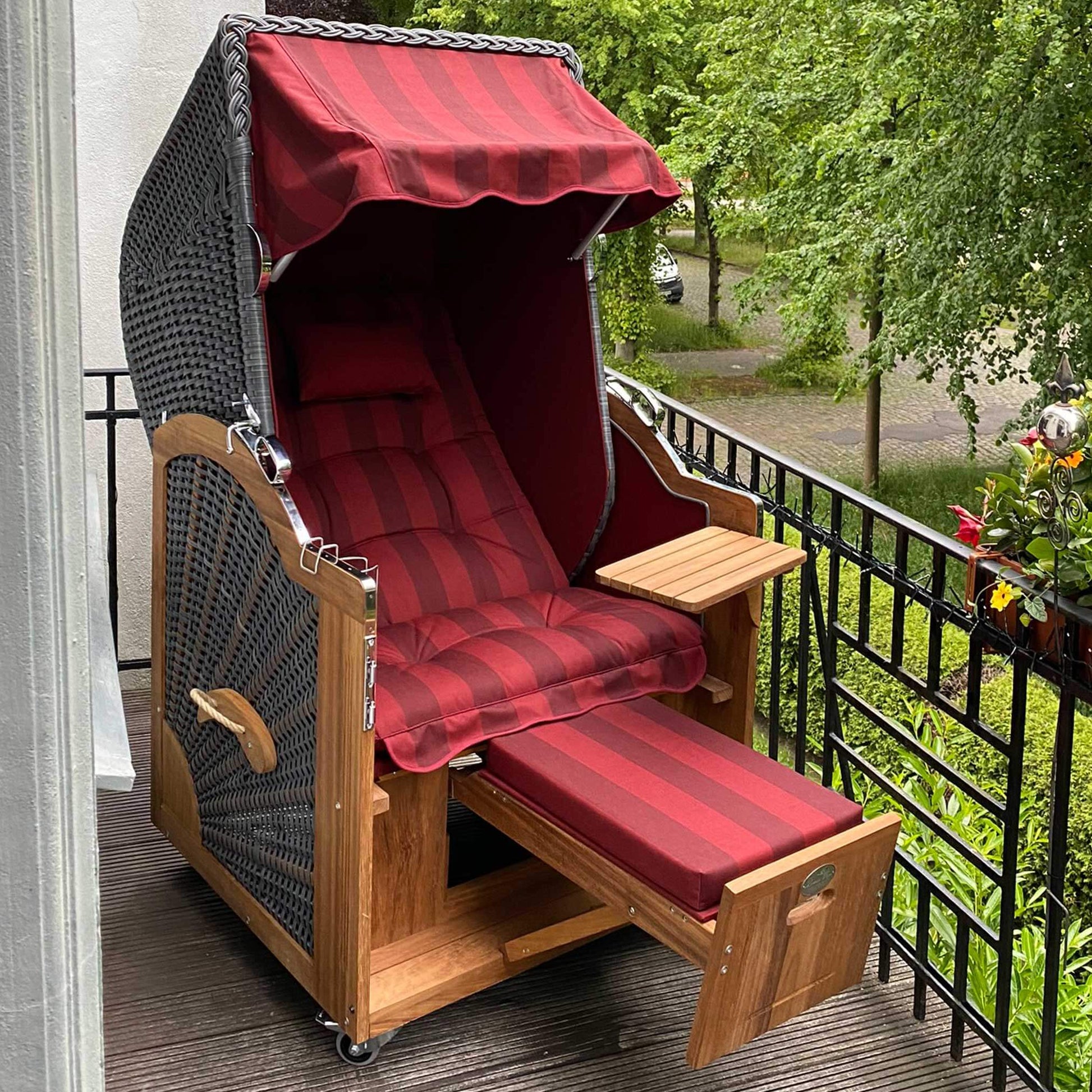 Strandkorb Prieß, Modell Meister aus Iroko Holz mit dunkelgrauem PE Geflecht und bordeaux gestreiftem Stoffdessin.