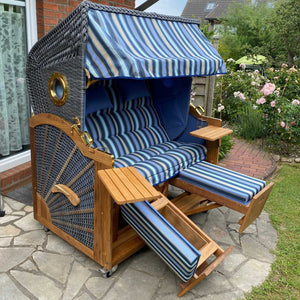 Strandkorb Prieß, Modell Meister, aus Iroko Holz und anthrazit PE-Geflecht, mit blau-hellblauem Stoff-Dessin.