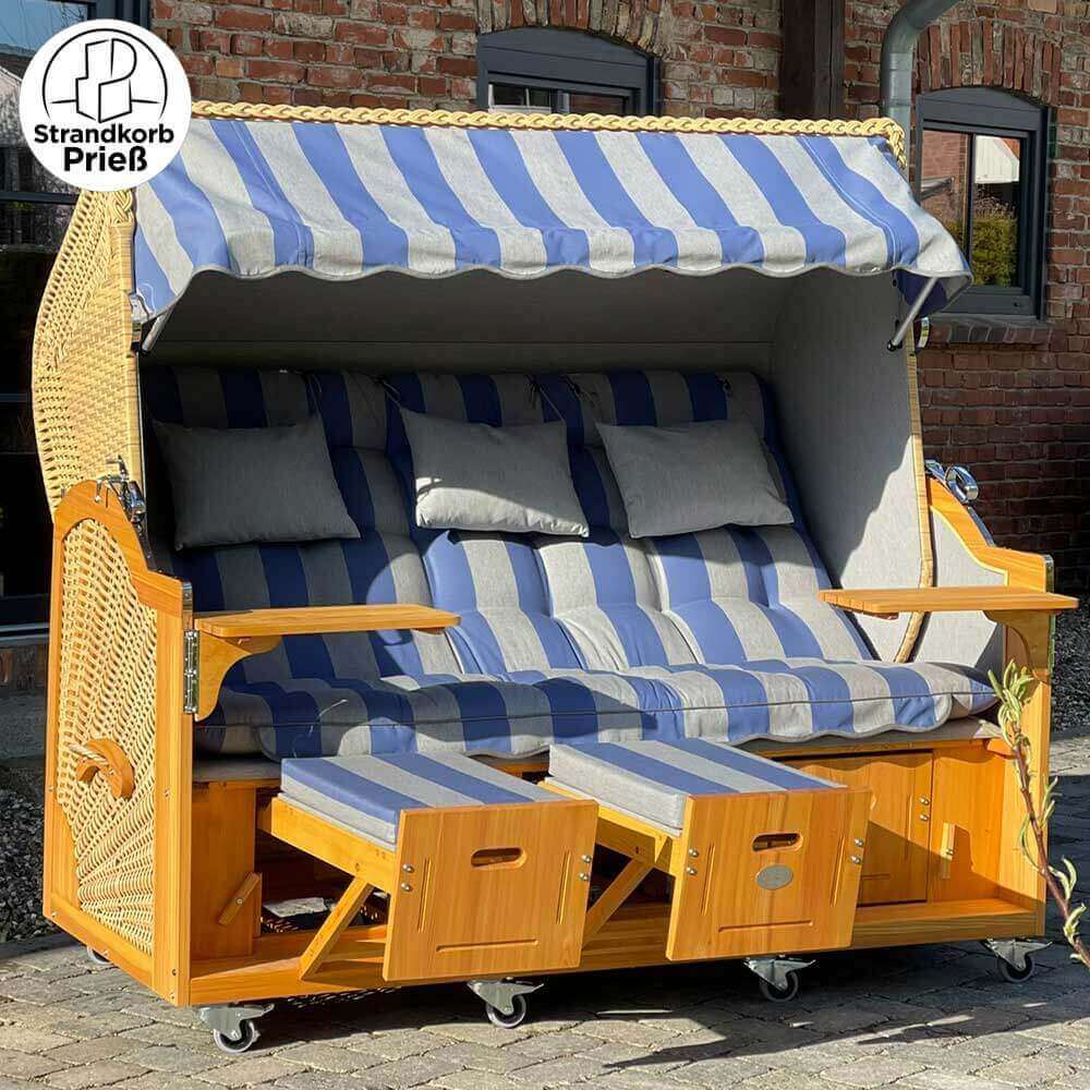 Strandkorb Prieß Meister Lärche Holz mit blau-gestreiftem Stoffdessin, zwei Fußstützen und bequemem Polster.
