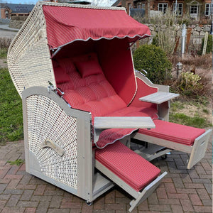 Strandkorb Prieß Modell Meister, Lärche Holz, vintage grau lasiert, PE Geflecht taupe, mit rot gestreiftem Stoffdessin.