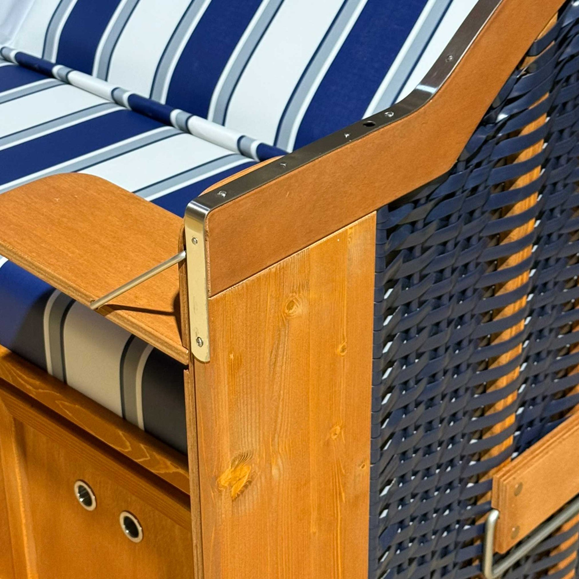 Detailansicht des Strandkorbs Sonnenpartner Classic mit Holz- und PVC-Oberfläche in blau und weißen Streifen.