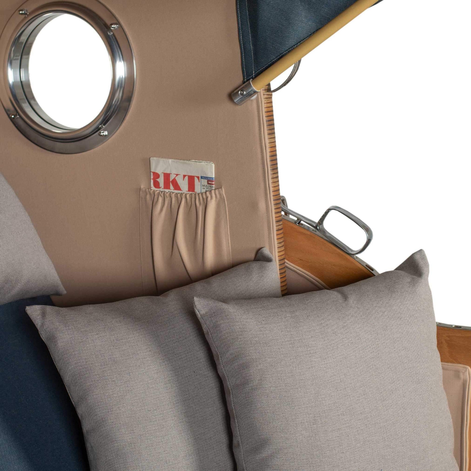 Detailansicht des Strandkorbs Mr. Deko Düne mit Bullaugen und Kissen für Komfort im Freien.