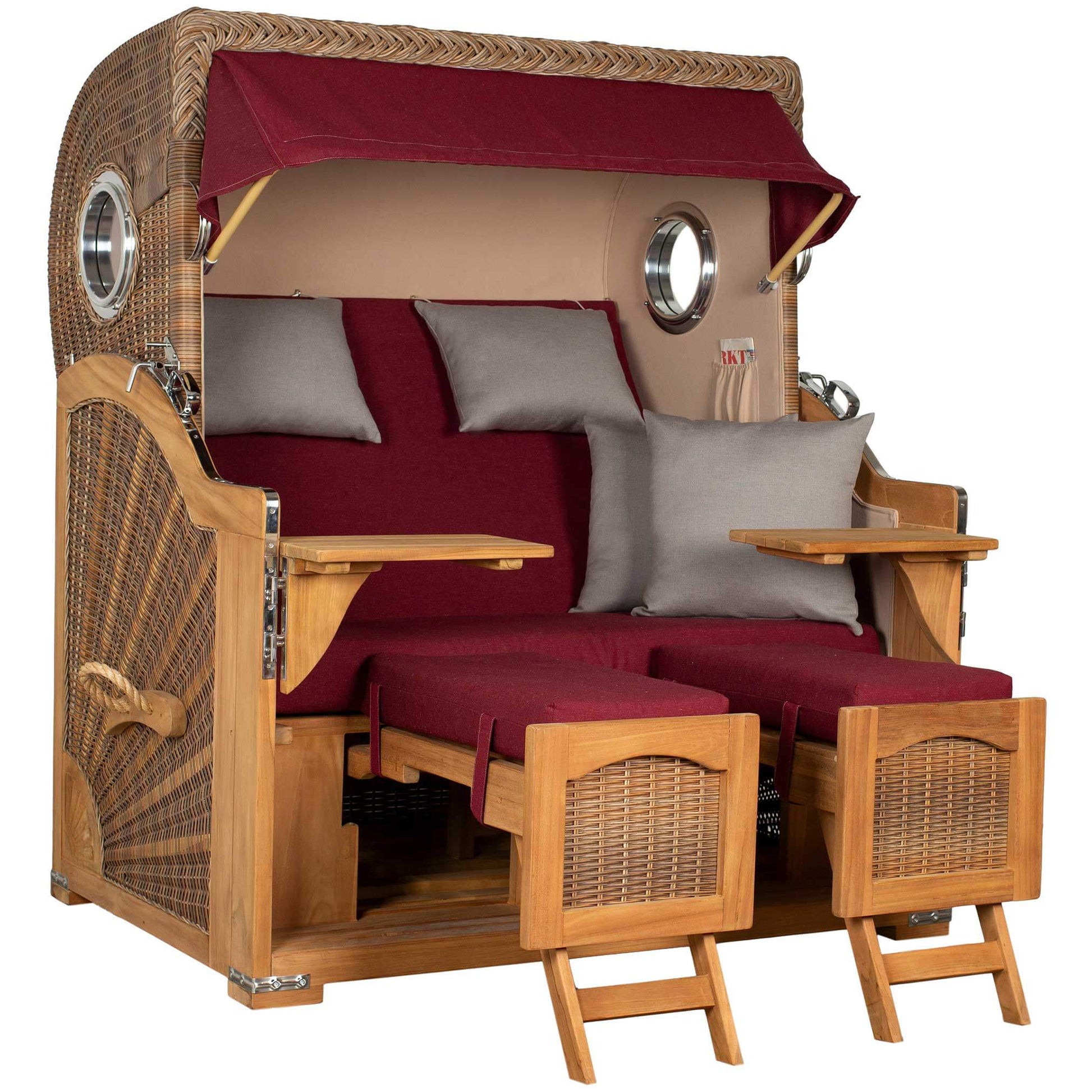 Strandkorb Düne Grande Bullaugen Teak PE banana 2,5-Sitzer in Rot mit stilvollen Kissen und zwei Fußstützen.