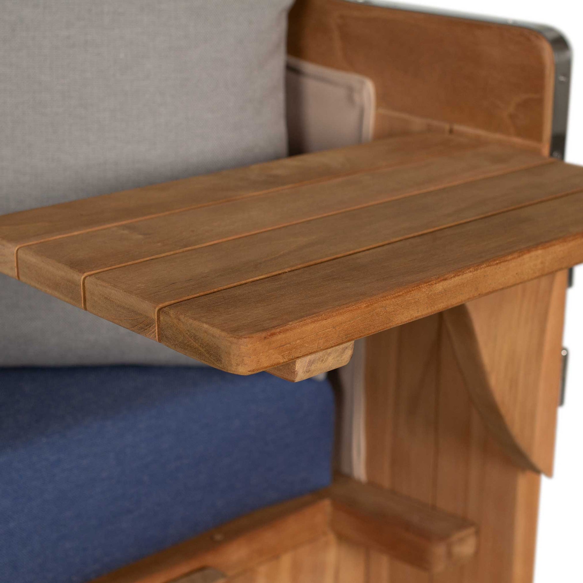 Detailaufnahme des Holzarmlehne des Strandkorbs Mr. Deko Düne Grande mit Teak-Oberfläche und bequemem Polster.