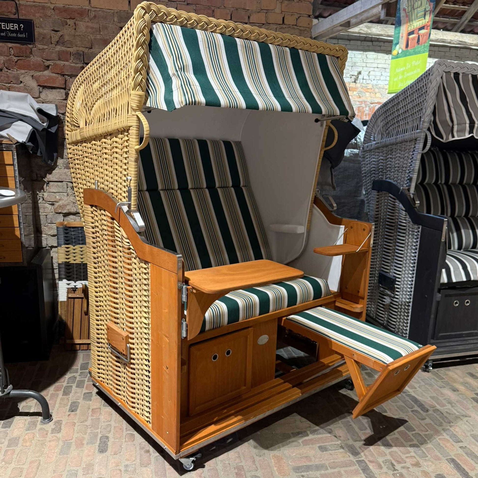 Strandkorb Sonnenpartner Classic 2-Sitzer in Naturoptik mit grün gestreiftem Dessin 14 und ausgezogener Fußstütze in Innenraum