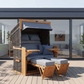 Strandkorb deVries PURE Friesland Sylt Teak PE stone grey Dessin 253 auf moderner Dachterrasse mit Fußstützen und blauen Polstern