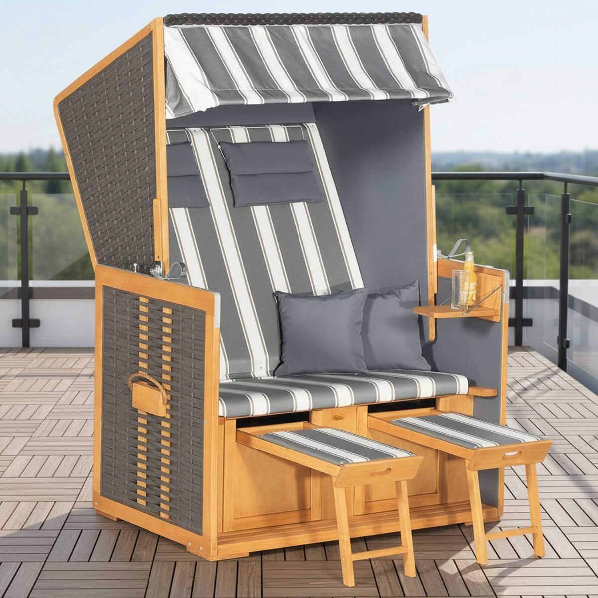 Strandkorb Rustikal 10 Z Vintage-braun auf einer Terrasse mit gestreiften Kissen und Fußstützen.