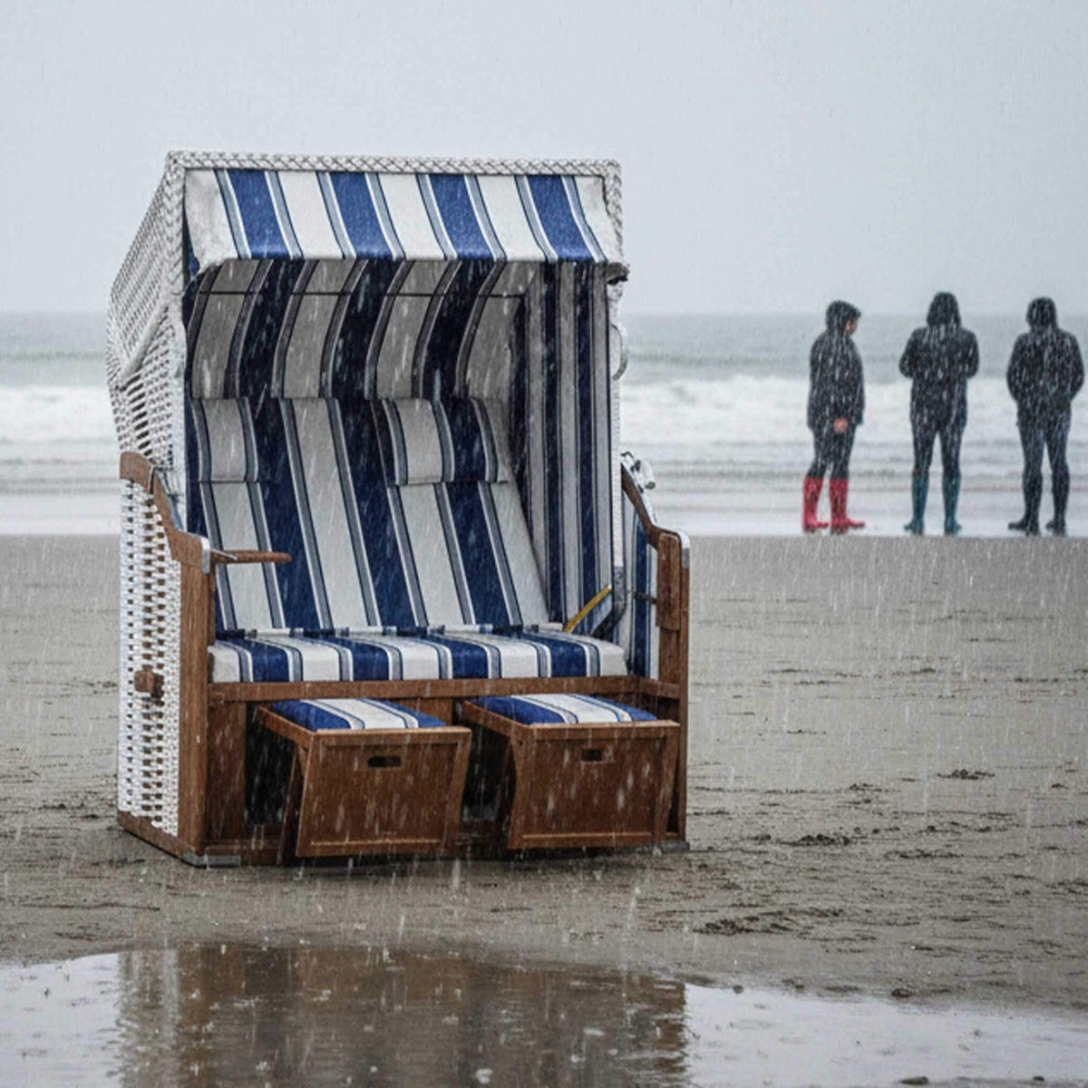 Strandkorb SunnySmart Rustikal 250 Basic in der Regen am Strand, blau-weiße Streifen und komfortable Polster.