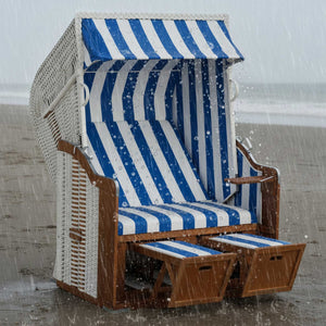 Strandkorb blau weiss am Strand bei Regen