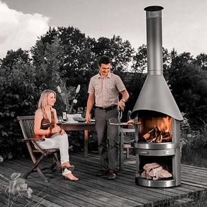 HermaPro Edelstahl Gartenkamin Vario mit glatter Haube auf Terrasse, Paar grillt und genießt Feuer im hochwertigen Gartenkamin
