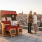 Strandkorb deVries PURE Seemöwe Teak PE stone grey Dessin 107 auf Dachterrasse mit Ausblick über die Stadt bei Sonnenuntergang