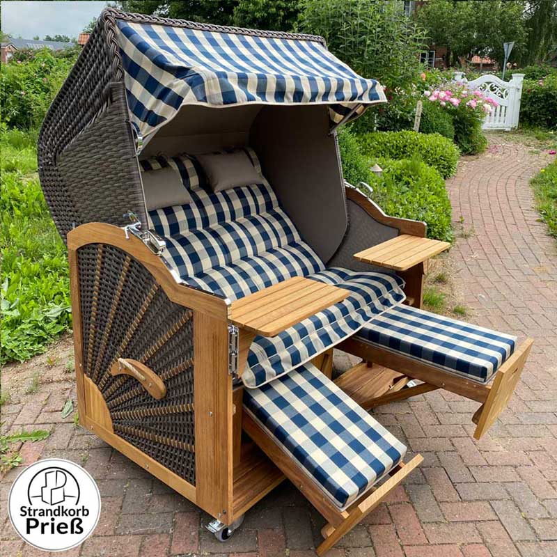Strandkorb Prieß Modell Meister aus Iroko Holz mit cappuccino PE-Geflecht und blau kariertem Stoff-Dessin im Garten