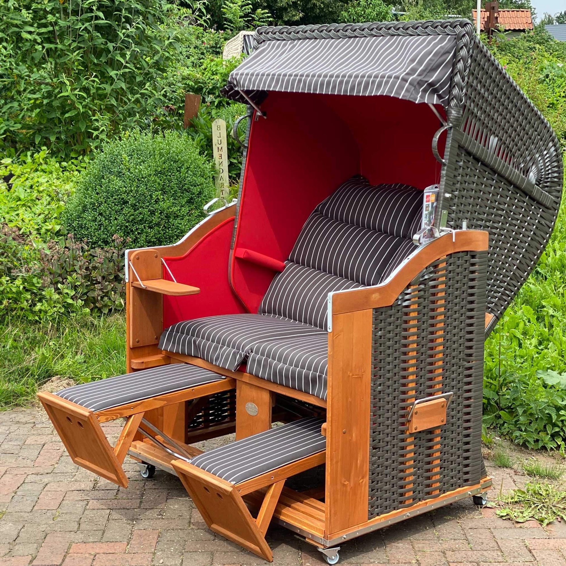 Strandkorb Sonnenpartner Modell Classic in Anthrazit mit rotem Dessin, Komfort mit Klapptischen und Fußstützen.