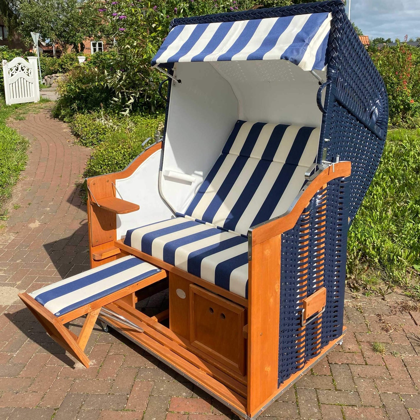 Strandkorb Sonnenpartner Modell Classic blau mit Streifenmuster und Fußstützen, perfekt für entspannte Tage im Freien.