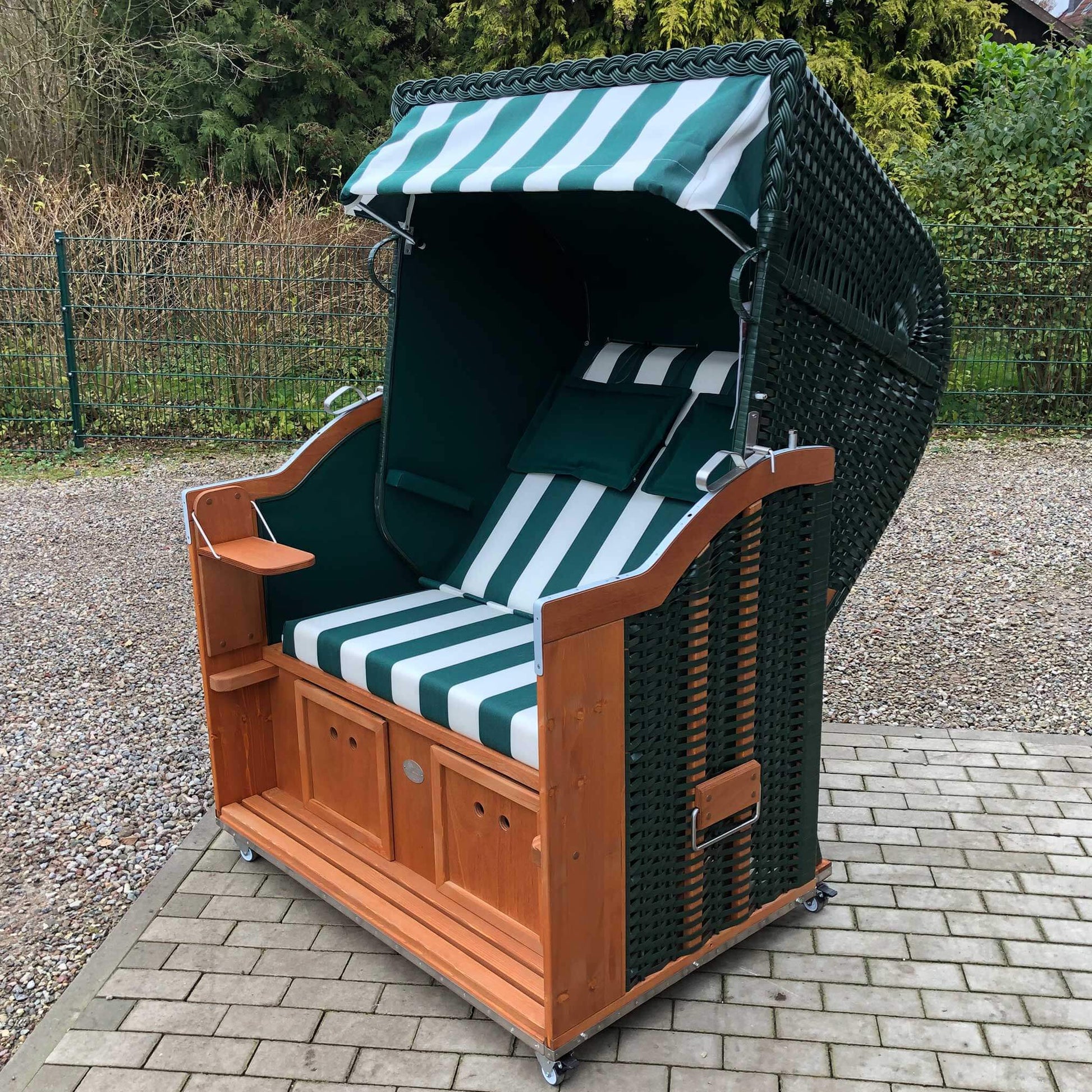 Strandkorb Sonnenpartner Modell Classic in grün mit Fahrrollen und Komfortkopfkissen, Holz lasiert und gestreifter Innenstoff.