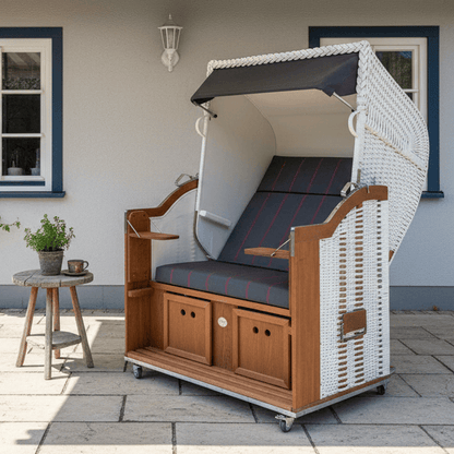 Strandkorb Sonnenpartner Modell Classic weißes Geflecht mit anthrazit Markise und Rollen auf Terrasse vor Hauswand