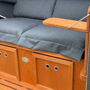 Strandkorb Sonnenpartner Modell Konsul mit grauen Polstern und Holzaufbau, komfortabler 2-Sitzer für entspannte Stunden.