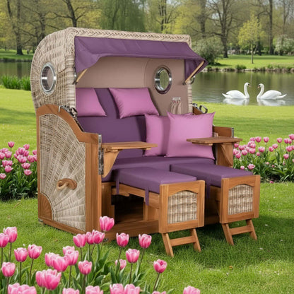 Strandkorb Mr. Deko Düne Bullaugen Teak PE shell 2-Sitzer in einem blühenden Garten mit Tulpen.
