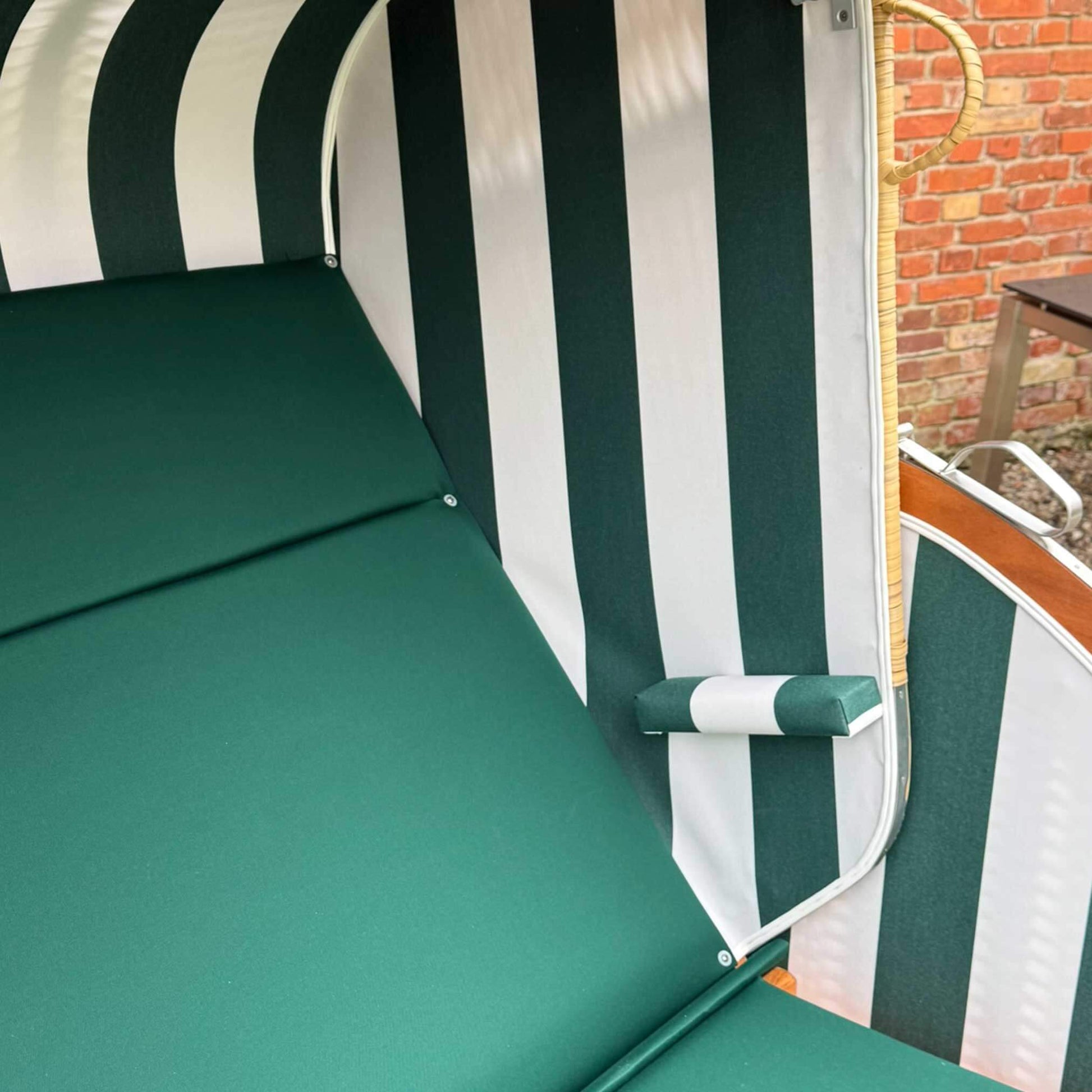 Strandkorb Sonnenpartner Modell Classic PE Naturoptik mit grün-weißem Bezug und seitlichem Kopfpolster.