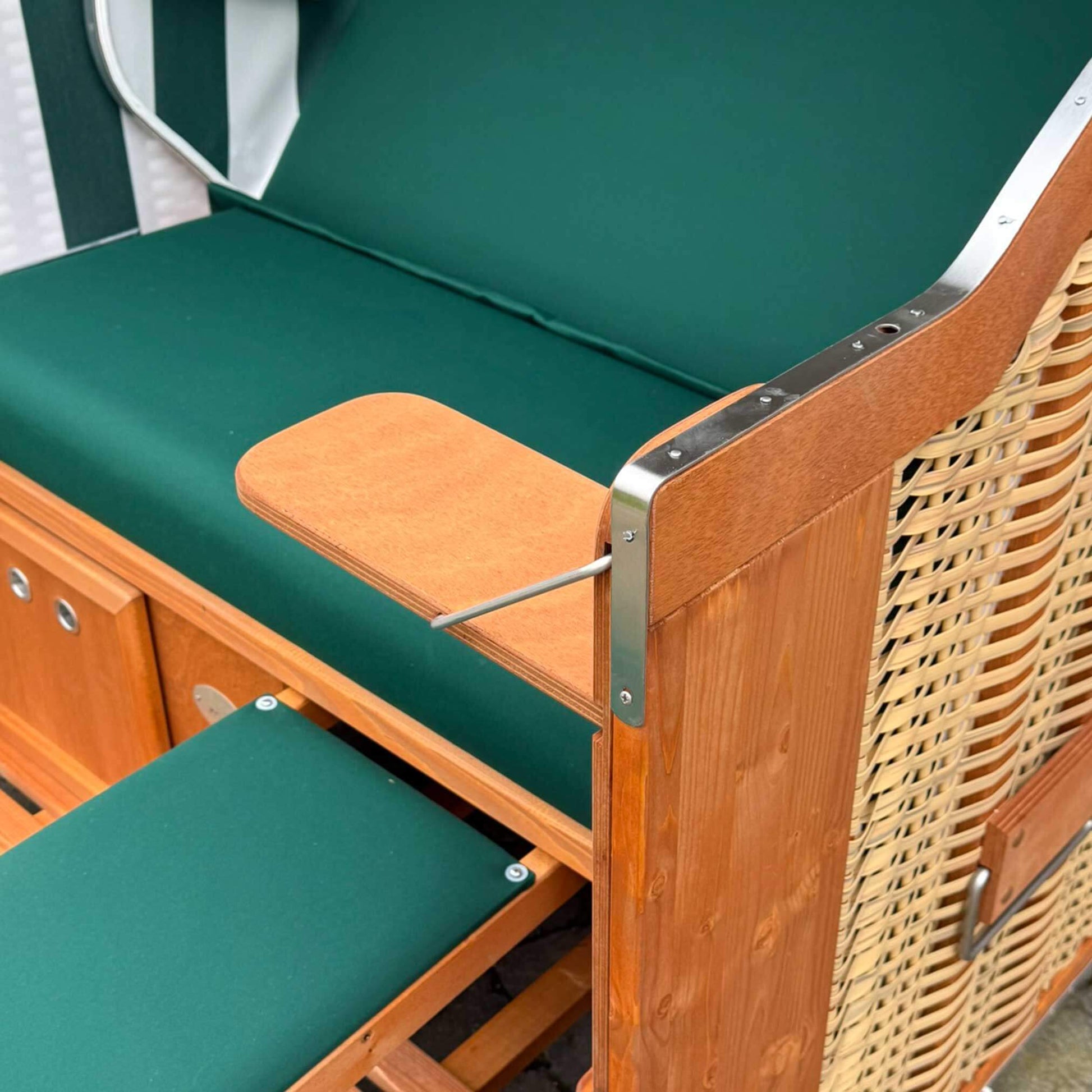 Detailansicht des Strandkorb Sonnenpartner Modell Classic mit grünem Polster und Holzverarbeitung.