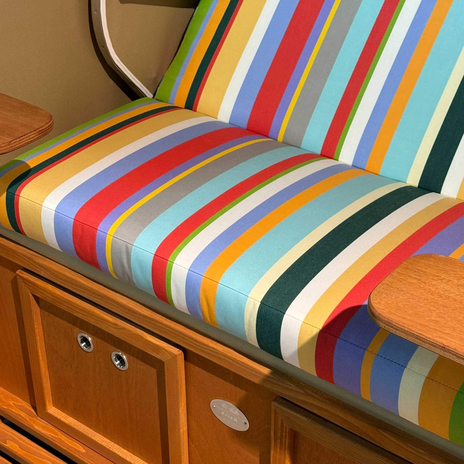 Strandkorb Sonnenpartner Modell Classic PE Naturoptik mit buntem gestreiften Polster und Holzoberfläche.