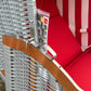 Detailaufnahme vom Strandkorb Sonnenpartner Classic rot weiß mit rotem Polster und Holzarmlehne.