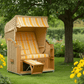 Strandkorb Sonnenpartner Modell Classic PE Rundgeflecht Naturoptik gelb gestreift im blühenden Garten unter Baum