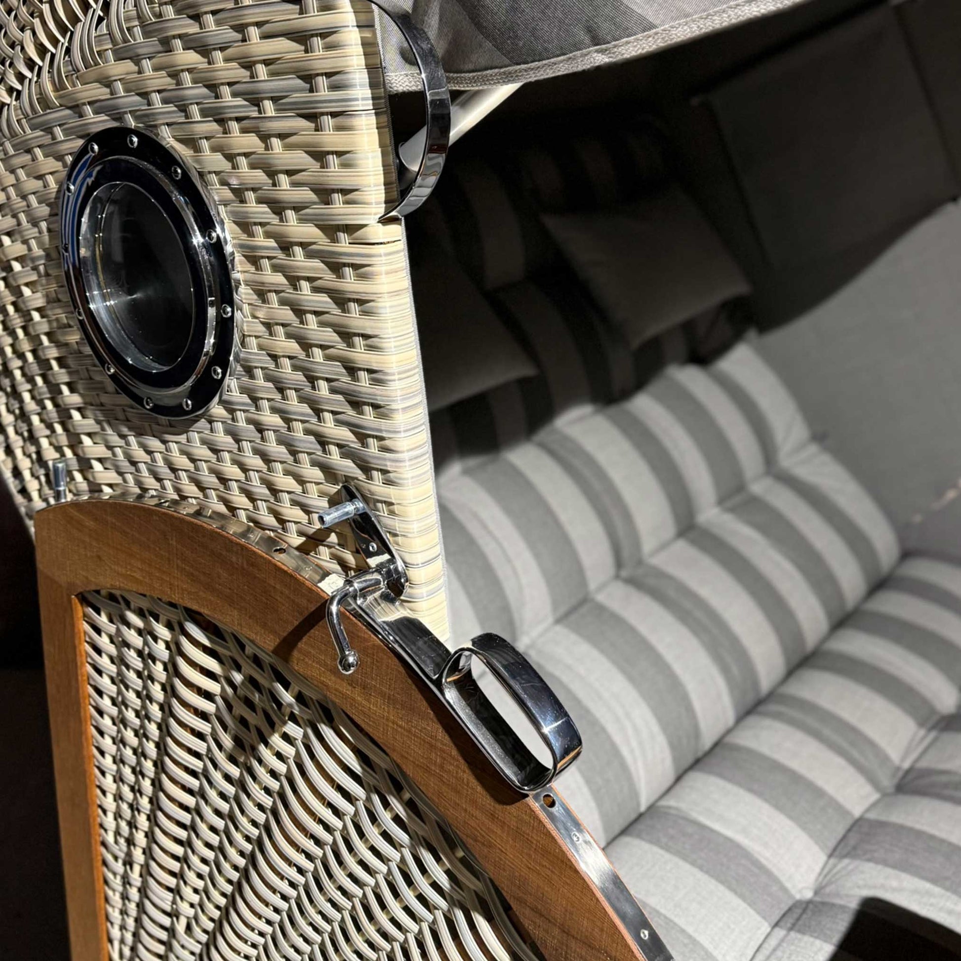 Detailaufnahme des Strandkorb Prieß, Modell Meister mit anthrazit PE Geflecht und gestreifter Polsterung.