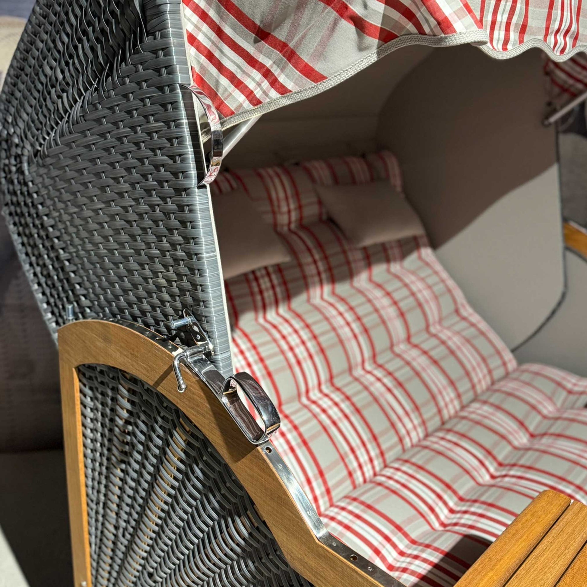 Strandkorb Prieß Modell Meister aus Iroko-Holz mit dunkelgrauem PE-Geflecht und rot-weiß gestreifter Polsterung, Detailansicht