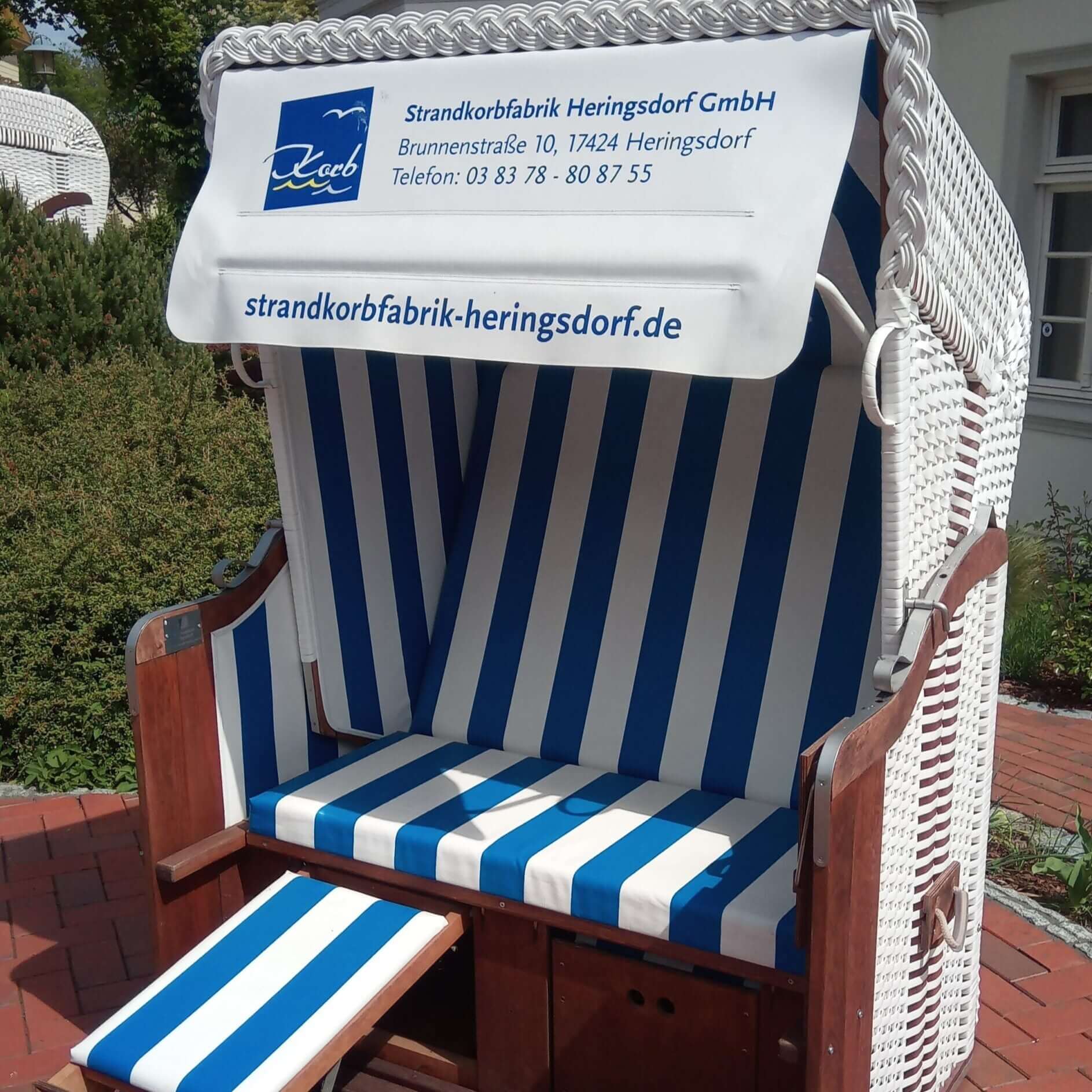 Werbe-Strandkorb Usedom mit individualisierter Markise in blau-weißer Streifenoptik, 2-Sitzer Halblieger.
